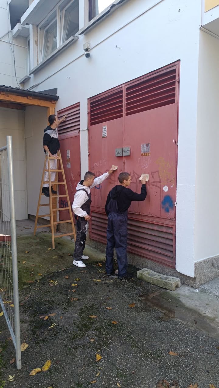 Učenici čiste i pripremaju metalna vrata za farbanje