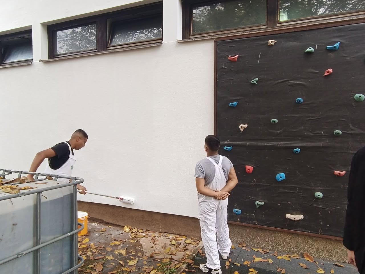 Učenici rade valjkom na vanjskom zidu škole